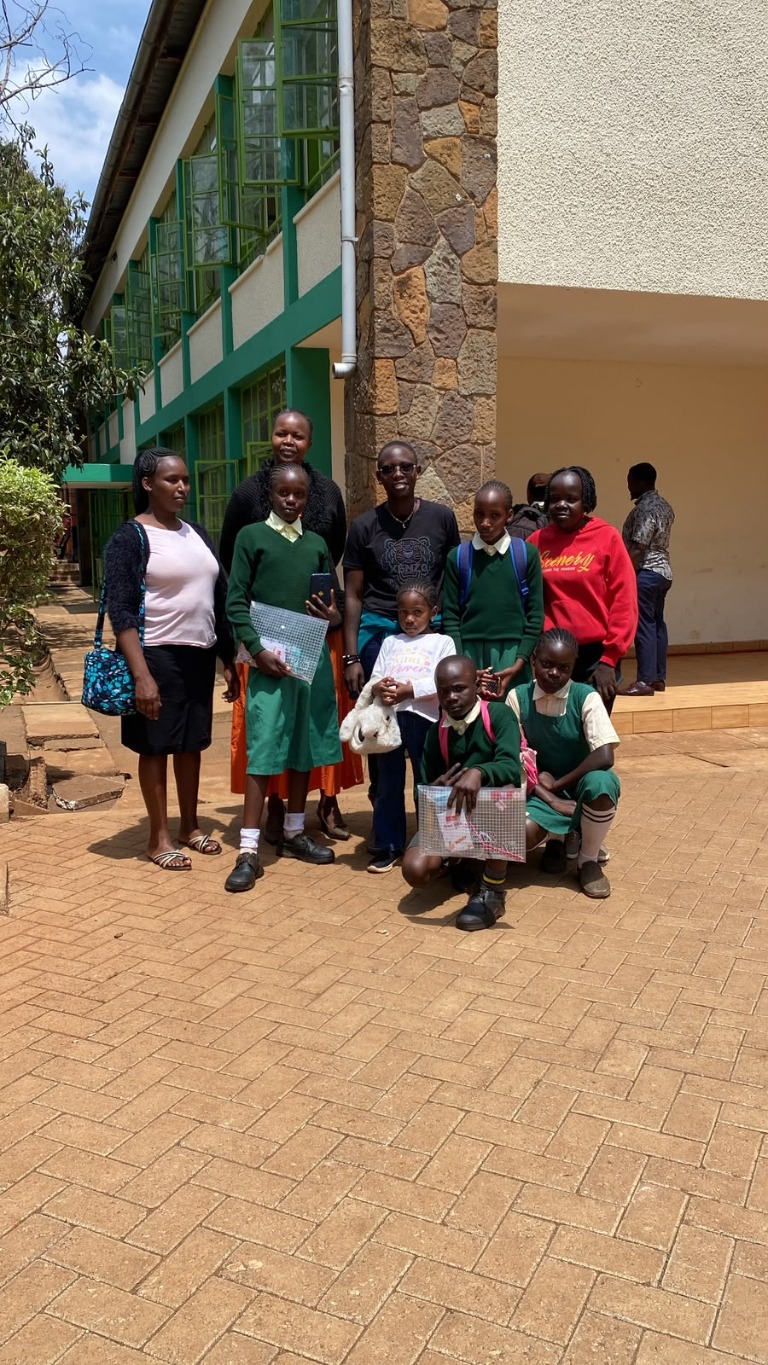 Academy members and students gathered outside a school.