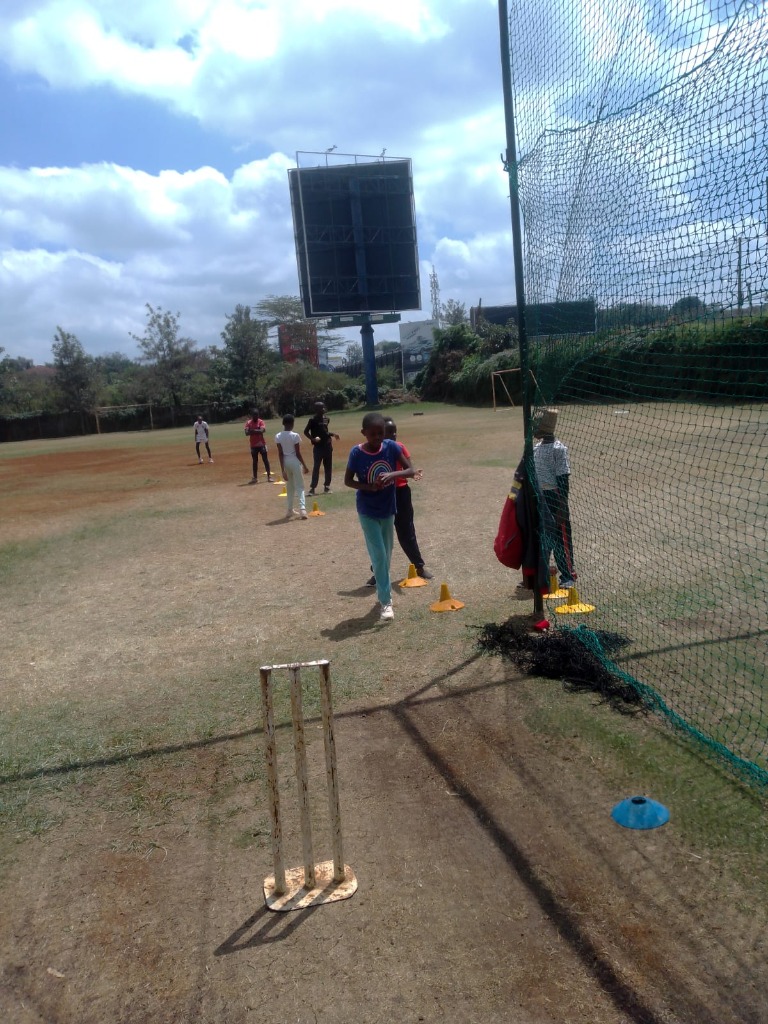 Girls taking part in an outdoor cricket training session.